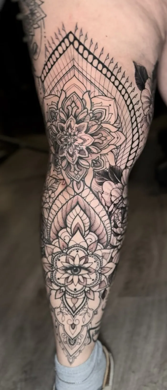 Fine line ornamental leg tattoo with mandalas, flowers, lace details and an eye in black and grey by Duk Tattoo, Boca Raton, Florida