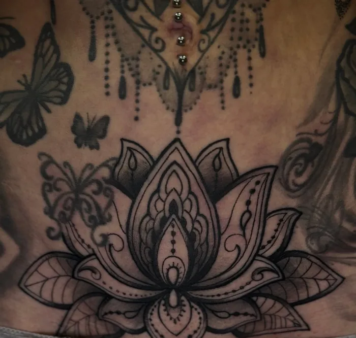 Ornamental lotus tattoo in fine line and black shading with butterflies on the lower belly of a woman by Duk Tattoo, Boca Raton, Florida