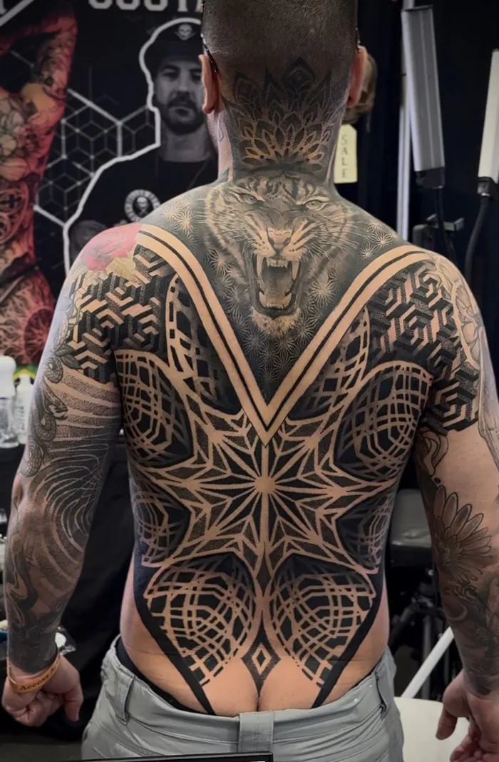 Full back geometric tattoo with a black and grey tiger, star mandala and ornamental lines by Duk Tattoo, Boca Raton, Florida