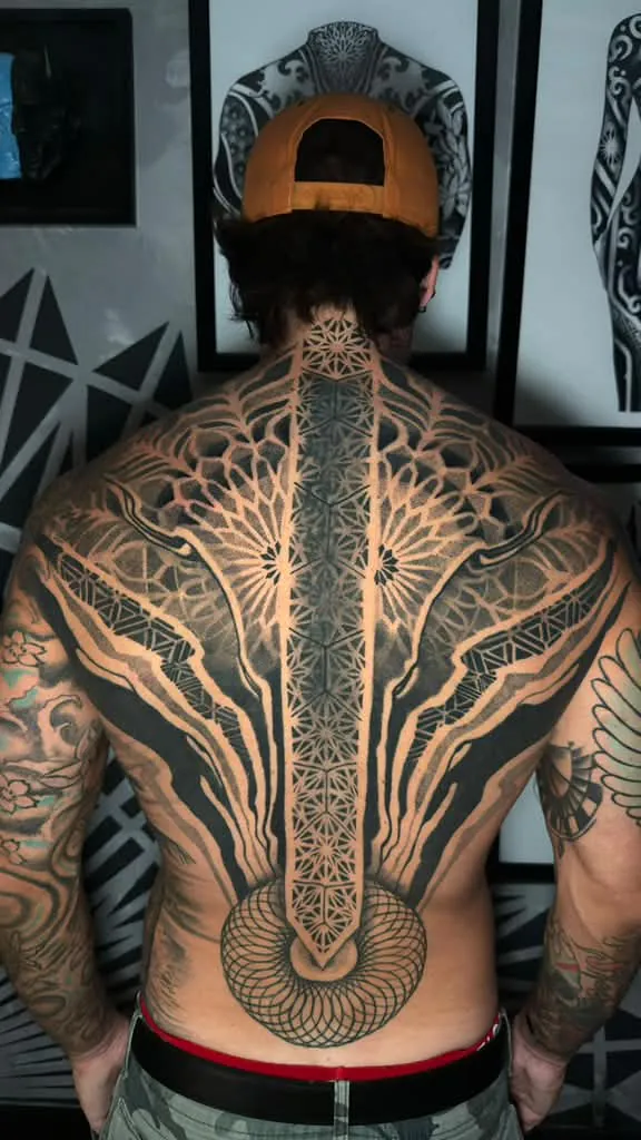 Full back piece sacred geometry tattoo with a spine line, mandala and symmetrical dotwork in black and grey by Duk Tattoo, Boca Raton