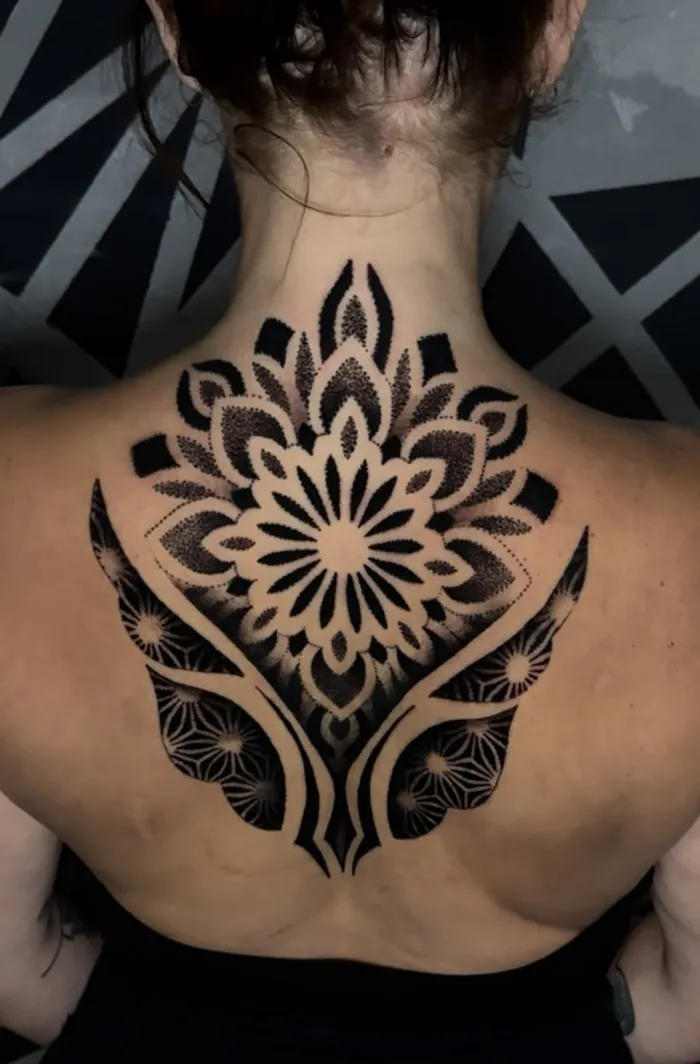 Upper back and neck mandala tattoo in bold blackwork with dotwork shading on a woman by Duk Tattoo, Boca Raton, Florida
